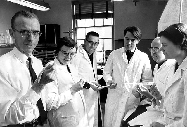 Robert W. Holley, left, poses with his research team.