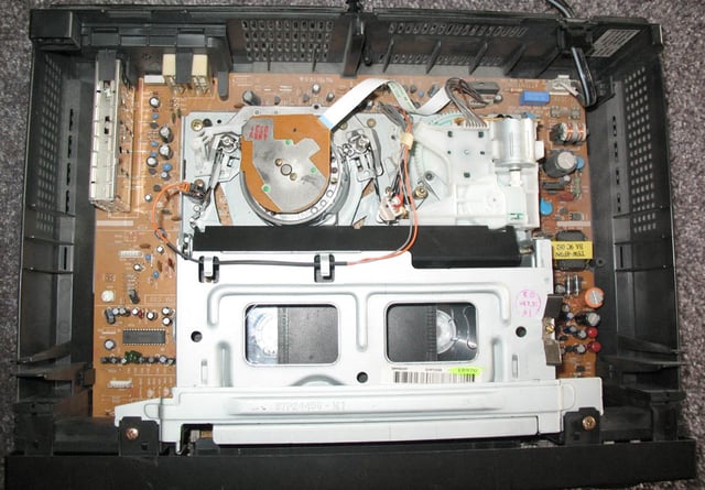 The interior of a modern VHS VCR showing the drum and tape.