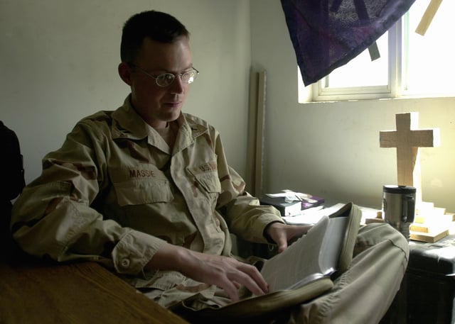 A U.S. Navy chaplain in Iraq studies his Bible for an upcoming service.