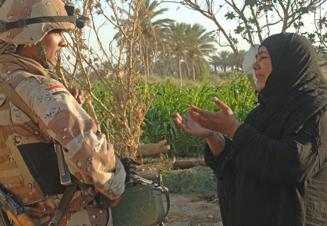 A woman pleads with an Iraqi army soldier from 2nd Company, 5th Brigade, 2nd Iraqi Army Division to let a suspected insurgent free during a raid near Tafaria, Iraq.