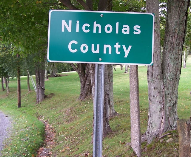 A highway sign designating the border between Nicholas and Greenbrier counties in West Virginia along a secondary road