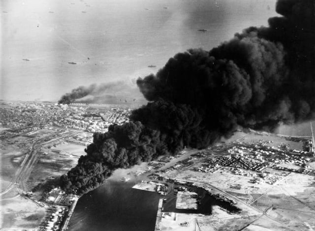 Smoke rises from oil tanks beside the Suez Canal hit during the initial Anglo-French assault on Port Said, 5 November 1956.