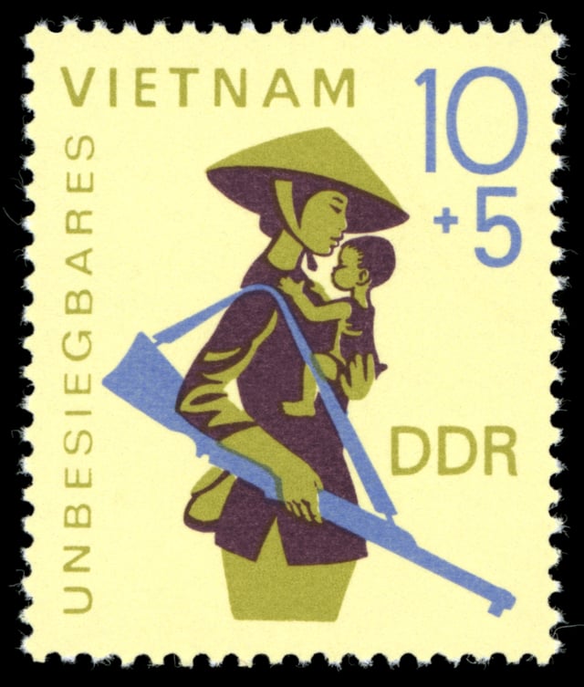 East German solidarity stamp depicting a Vietnamese mother and child with the text "Invincible Vietnam"