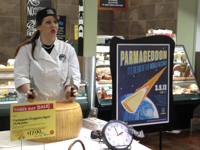 Preparing to break open a wheel of Parmigiano-Reggiano cheese at Whole Foods Market in Overland Park, Kansas