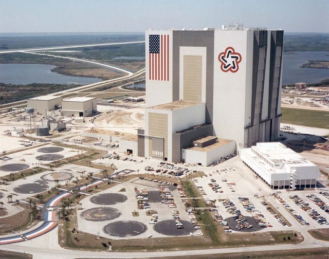 The NASA Vehicle Assembly Building in 1977. The VAB has the largest U.S. flag ever used on a building, and with the Bicentennial Star opposite the flag.