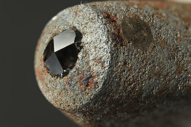 The extreme hardness of diamond in certain orientations makes it useful in materials science, as in this pyramidal diamond embedded in the working surface of a Vickers hardness tester.