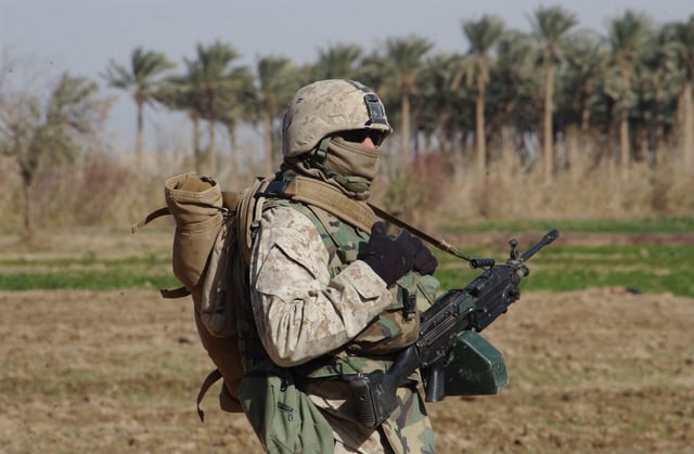 Machine gunner from 1st Platoon, Company B, 1st Battalion, 23rd Marine Regiment in cold weather gear armed with a Squad Automatic Weapon taking part in a security patrol around Ramadi, Iraq, 27 December 2006