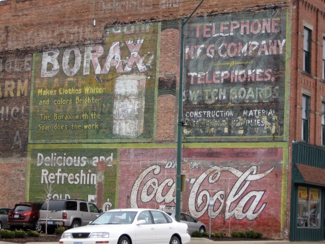 Coca-Cola ghost sign in Fort Dodge, Iowa. Older Coca-Cola ghosts behind Borax and telephone ads. April 2008.