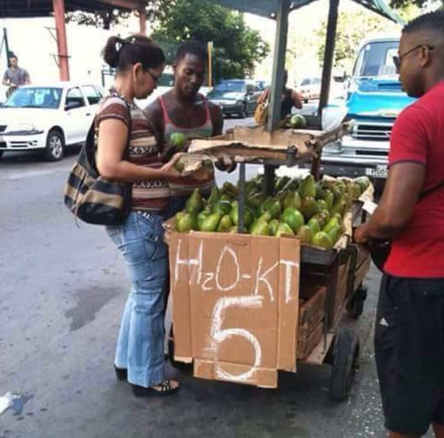 Selling avocados in Santo Domingo, Dominican Republic. The sign "H2O KT" is a play on aguacate, the Spanish word for avocado.