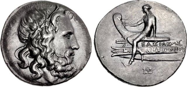 A tetradrachm minted during the reign of Antigonus III Doson (r. 229–221 BC), possibly at Amphipolis, bearing the portrait image of Poseidon on the obverse and on the reverse a scene depicting Apollo sitting on the prow of a ship