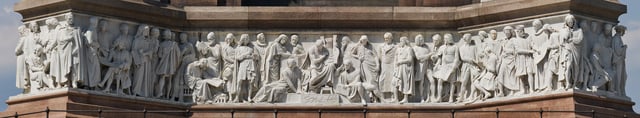 A face of the high-relief Frieze of Parnassus round the base of the Albert Memorial in London. Most of the heads and many feet are completely undercut, but the torsos are "engaged" with the surface behind.