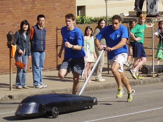Two pushers exchange the buggy for Kappa Delta Rho on the first hill of Sweepstakes.