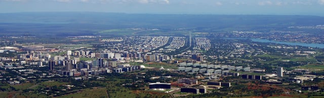 Aerial view of downtown Brasília (Pilot Plan) along the Monumental Axis, especially the new Mane Garrincha Stadium (left), the National Congress and the Three Powers Plaza (right). The entire residential area of North Wing (Asa Norte) is seen in the middle of the image.