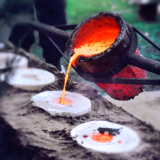 Liquid bronze, being poured into molds during casting.