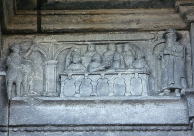 Carving of a 17th-century classroom with a dominie and his ten scholars. Positioned at the school's main entrance, the motto reads, DEVS NOBIS HAEC OTIA FECIT - "God hath given us this leisure"..