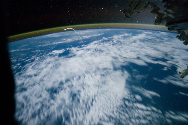 Glowing plasma trail from Space Shuttle Atlantis re-entry as seen from the Space Station