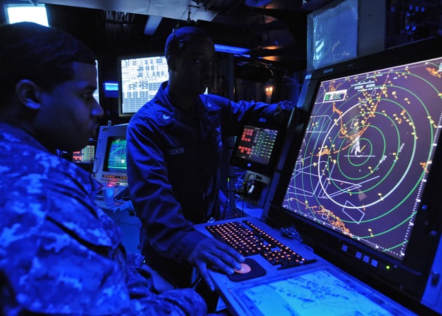 Military air traffic controller on US Navy aircraft carrier monitors aircraft on radar screen