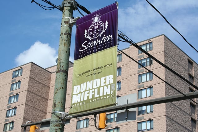 A banner promoting Dunder Mifflin, the fictional paper company on NBC's The Office, hangs in downtown Scranton.