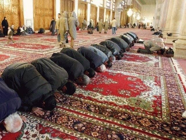 Muslim men prostrating in prayer, at the Umayyad Mosque, Damascus.