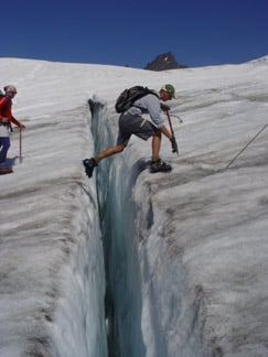 Crossing a crevasse on the Easton Glacier, Mount Baker, in the North Cascades, United States
