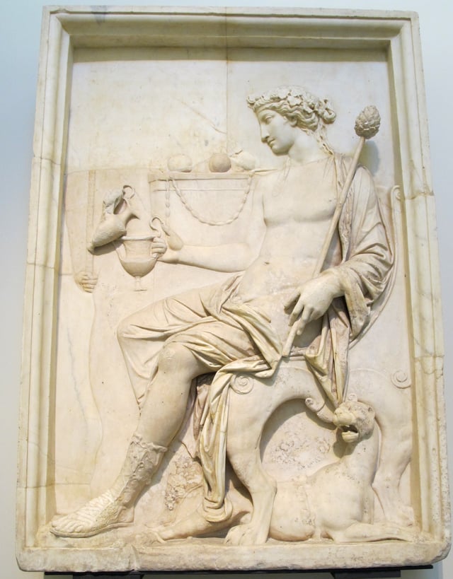 Ancient Roman relief in the Museo Archeologico (Naples) depicting Dionysus holding a thyrsus and receiving a libation, wearing an ivy wreath, and attended by a panther.