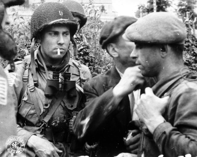 Members of the French Resistance and the U.S. 82nd Airborne division discuss the situation during the Battle of Normandy in 1944