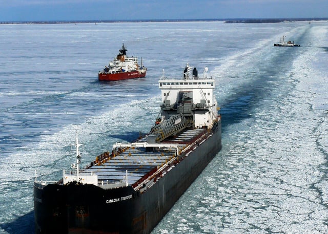 Channel through ice for ship traffic on Lake Huron with ice breakers in background
