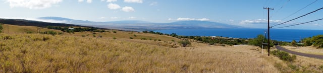 A view of the Kohala Coast and adjacent volcanoes, taken from the slopes of Kohala Mountains about 6 miles (10 km) northwest of Kawaihae. From left to right: Mauna Kea, Mauna Loa, and Hualalai.