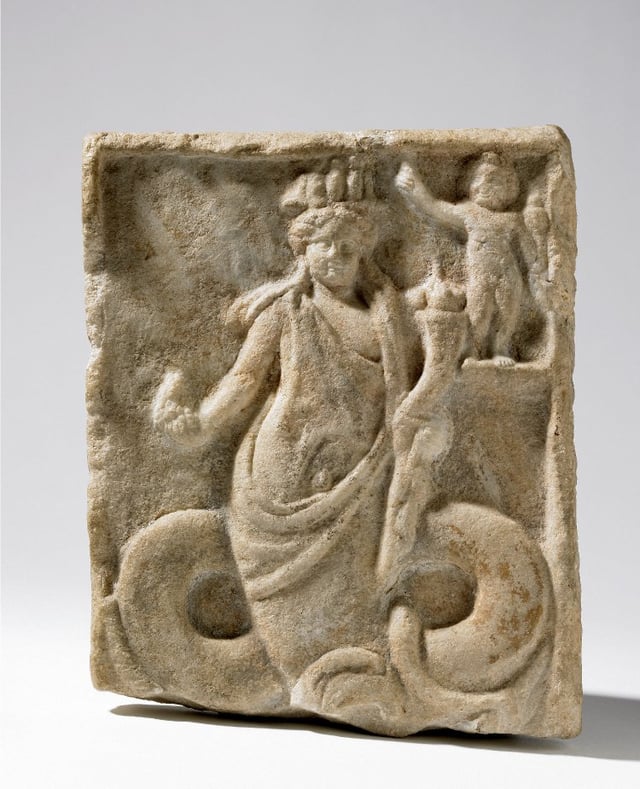 Roman marble relief (1st century AD) from Naukratis showing the Greek god Dionysus, snake-bodied and wearing an Egyptian crown.