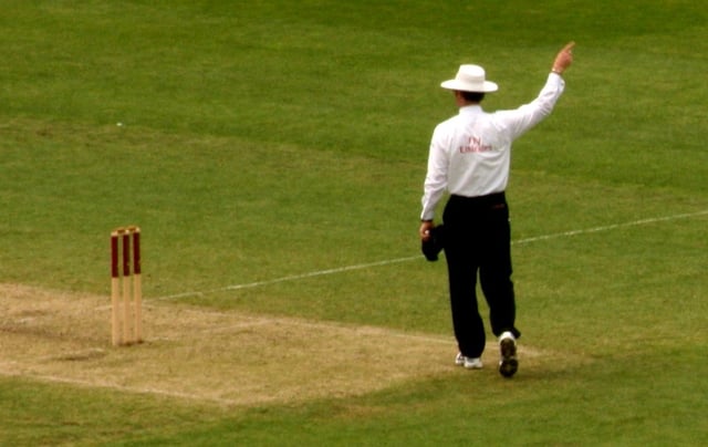 An umpire signals a decision to the scorers