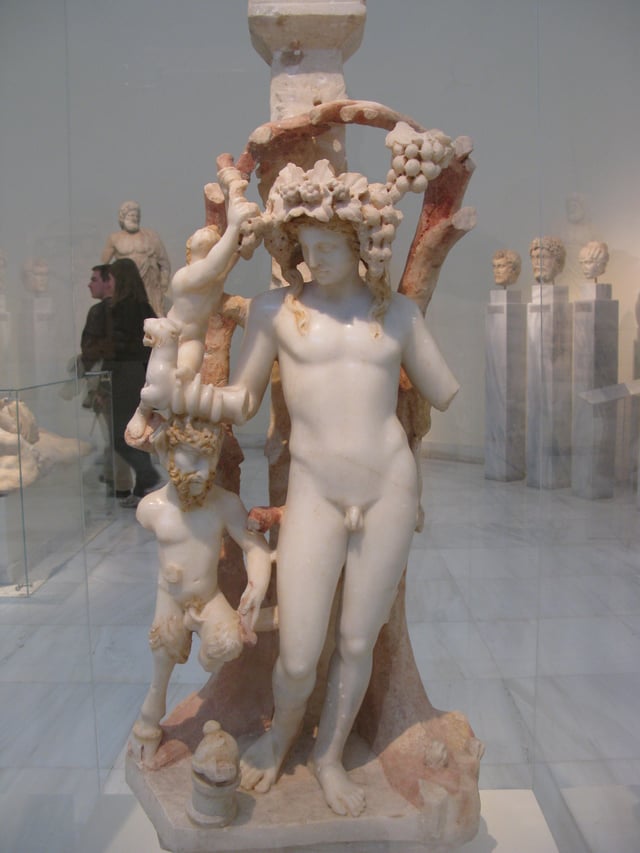 Marble table support adorned by a group including Dionysos, Pan and a Satyr; Dionysos holds a rhyton (drinking vessel) in the shape of a panther; traces of red and yellow colour are preserved on the hair of the figures and the branches; from an Asia Minor workshop, 170–180 AD, National Archaeological Museum, Athens, Greece