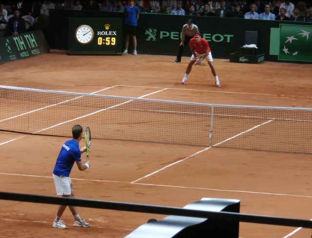 Federer receiving serve against Richard Gasquet in the title clinching match for Switzerland at the 2014 Davis Cup