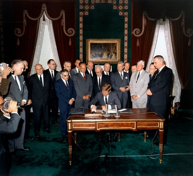 President Kennedy signs the Partial Test Ban Treaty, a major milestone in early nuclear disarmament in the Nuclear Age