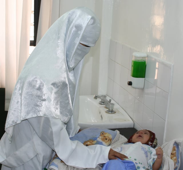 A Yemeni doctor examines an infant in a USAID-sponsored health care clinic