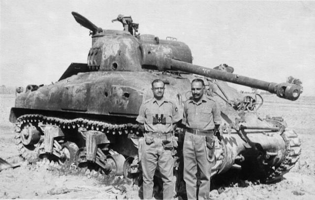 Indian Army officer next to a destroyed Pakistani Sherman tank, after the battle of Asal Uttar.