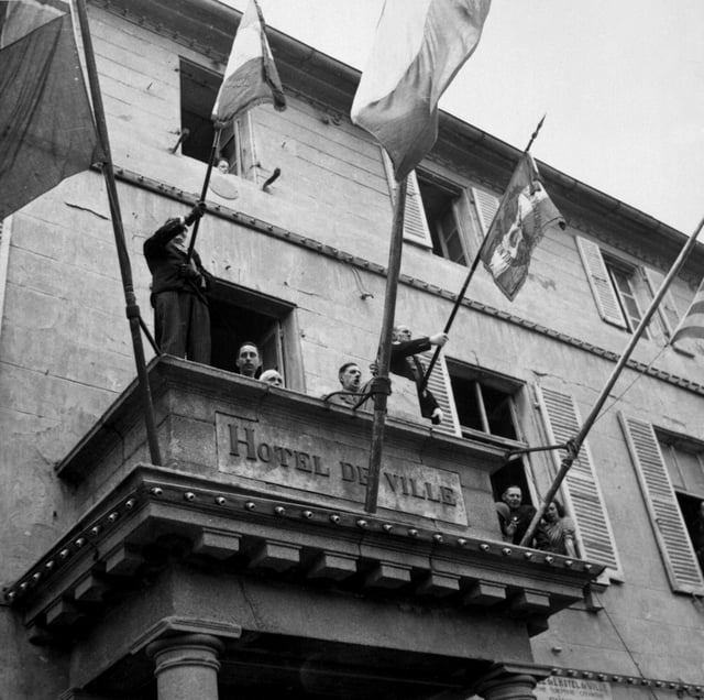 General de Gaulle delivering a speech in liberated Cherbourg from the hôtel de ville (town hall)