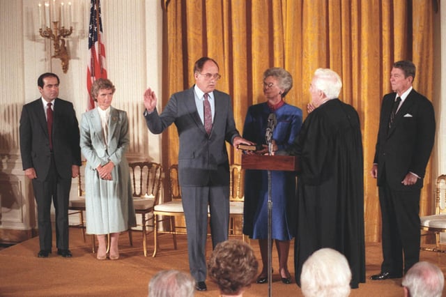 Judge and Mrs. Scalia (left) and President Reagan (right) watch as Chief Justice Warren Burger swears William Rehnquist in as the next Chief Justice, September 26, 1986.
