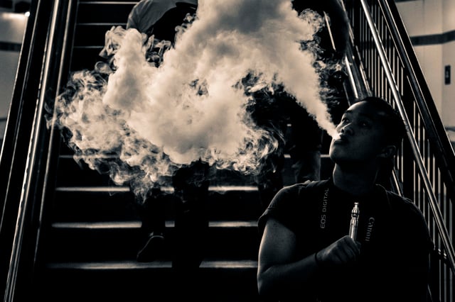 E-cigarette user blowing a cloud of aerosol (vapor).