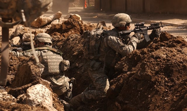 U.S. soldiers take cover during a firefight with insurgents in the Al Doura section of Baghdad, 7 March 2007.