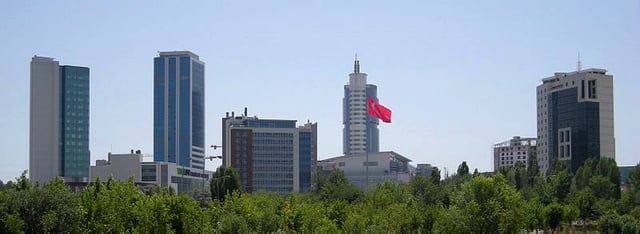 Söğütözü business district in Ankara, as seen from the Atatürk Forest Farm and Zoo, with the Armada Tower & Mall (2002) rising behind the Turkish flag.