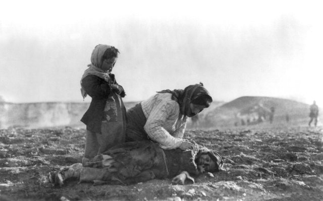An Armenian woman kneeling beside a dead child in a field "within sight of help and safety at Aleppo"