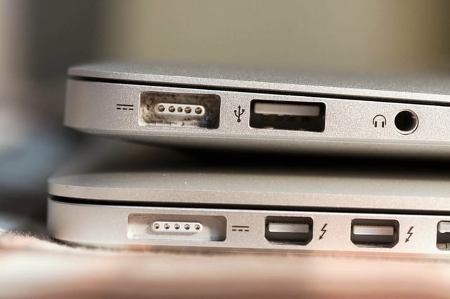 A MacBook Air (top) and a third generation Retina MacBook Pro (bottom). The MacBook Pro has a thinner MagSafe 2 port and two Thunderbolt ports.