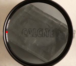 Doubly refracted image as seen through a calcite crystal, seen through a rotating polarizing filter illustrating the opposite polarization states of the two images.