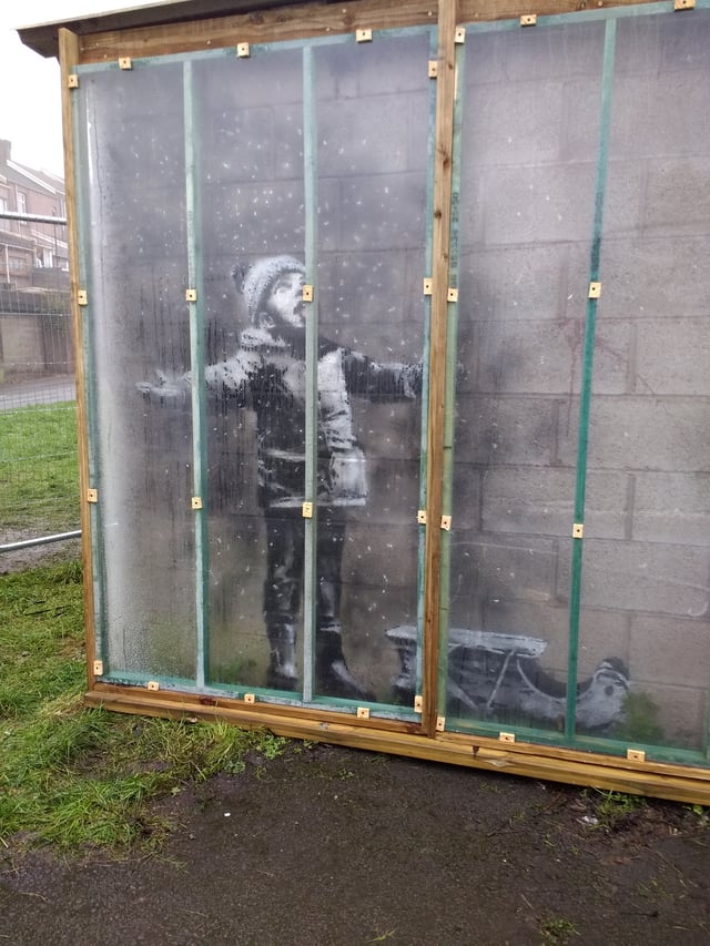 Season's Greetings was created by Banksy in Port Talbot, Wales, in December 2018, and was quickly provided with a temporary protective covering to prevent vandalism.