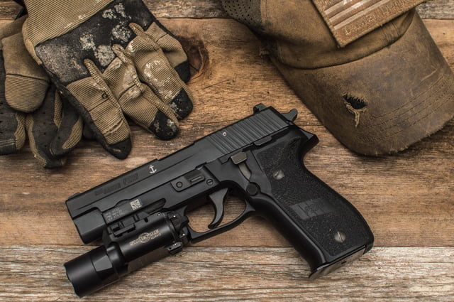 A P226 Mk25 model featuring the UID barcode, Silver Anchor and a Surefire X300 Ultra weapon light mounted on the Picatinny rail.