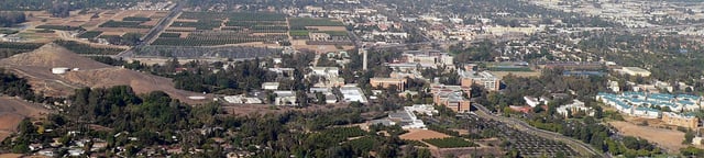 Panoramic view of campus from the Box Springs Mountain. Student housing is to the far lower right, north of which are the athletic facilities. The dense vegetation to the lower left constitutes the Botanic Gardens. The agricultural fields in the central left are designated for future campus development. (2007)