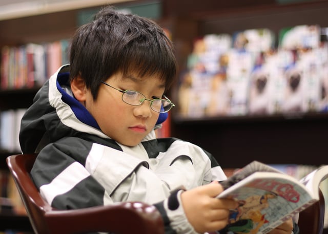 A young boy reading Black Cat