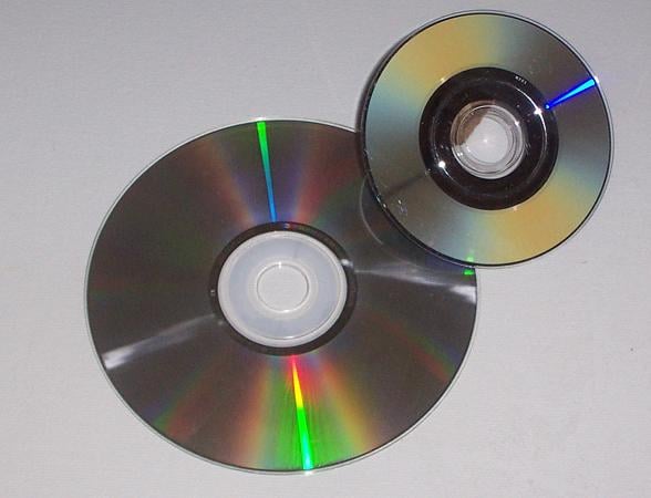 Shown is a CD-ROM (left) and a game in Nintendo's proprietary optical disc format similar to a MiniDVD, as the most widely used forms of optical media are DVDs and compact discs