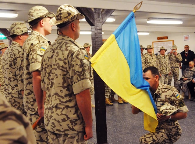 Henadii Lachkov, commander of the Ukrainian contingent in Multi-National Force – Iraq, kisses his country's flag
