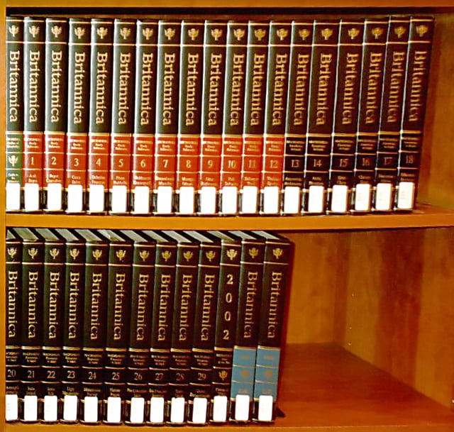 15th edition of the Britannica. The initial volume with the green spine is the Propædia; the red-spined and black-spined volumes are the Micropædia and the Macropædia, respectively. The last three volumes are the 2002 Book of the Year (black spine) and the two-volume index (cyan spine).